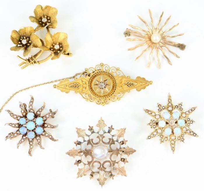 A Group of Six Brooches - Including 3 14 kt gold, opal, and pearl brooches, 1 14 kt yellow gold Victorian brooch with small diamond enhancement at the center, 1 brooch with three flowers all centered by small diamonds, and 1 medallion form brooch with moonstone center.  All but the last two mentioned brooches are marked.  Wear to each, some losses to the seed pearls, wear to the medal of the medallion form brooch.  Up to 1 5/8" long.  Totaling 20.9 grams.