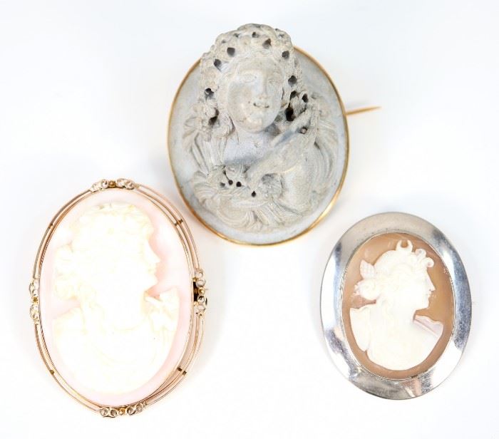 Three 19th Century Cameo Brooches.  Including 2 carved shell cameos, one featuring Diana the Huntress and one featuring the profile of a young woman, together with 1 high relief composition figure of a Bacchante.  No apparent markings.  Wear to each, the Bacchante brooch has some minor cracks and a flake verso.  Up to 1 1/2 x 1 7/8" high.  Totaling 61.5 grams.  
