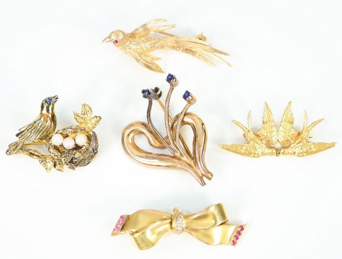 A Group of Five Brooches - Including 1 18 kt yellow gold and sapphire brooch, stamped "18", 3 14 kt yellow gold brooches consisting of 1 bird with ruby eye, 1 pair of turtle doves with single pearl accent, and 1 bow form with diamond and ruby accents, along with 1 gold over-sterling brooch in the form of a bird with her nest. All are marked accordingly. Minor wear to each. Up to 1.5" long.  Totaling 19.4 grams. 
