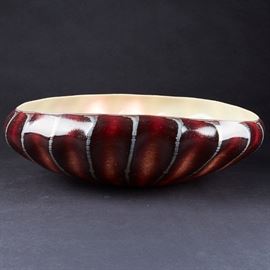 Lot #45 
Dale Chihuly (b. 1941). Deep red glass bowl with a tan interior and radiating designs along exterior ridges. Signed and dated 1981 along the bottom, and inscribed "Haystack."
Provenance: Directly from artist
Collection of Edward Claycomb.
Biography: Dale Chihuly first encountered glass art as an interior design student at the University of Washington. Immediately fascinated, he went on to study glass at the University of Wisconsin, which was the first university in the United States to teach glassblowing. From there, he went on to the Rhode Island School of Design, where he continued to learn about glass and eventually ended up teaching. His education continued with a Fulbright Fellowship to go to the famous glassblowing studios of Venice. After his time in Italy, he returned to his home state of Washington to found his own glass school, the Pilchuck Glass School, with Ann and John Hauberg, influential supporters of the arts in Seattle. At this school, his art style and proces