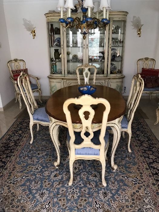 One of a kind handpainted French provincial dining room set. Eight chairs (table shown without leaf), four panel door, four shelf china cabinet with four bottom doors. Intricately  hand painted with a delicate floral and botanical design along apron, legs, backs, doors. 