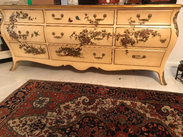 Handpainted French provincial bedroom set, with headboard, armoire, night stands, nine drawer, mirror. Shown in front of early 20th century Nouveau styled wool/silk Persian rug. 