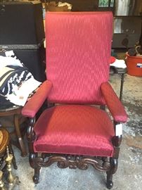 ornate upholstered armchair with high back and carved wood frame