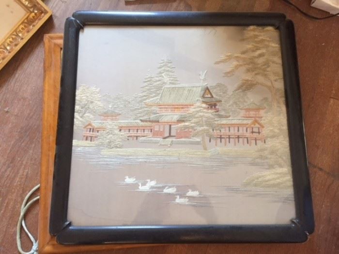 Chinese or Japanese landscape embroidery on silk in black wood frame.