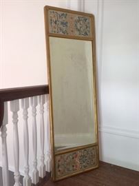 Old Chinese embroidery panels flank a vintage mirror. 