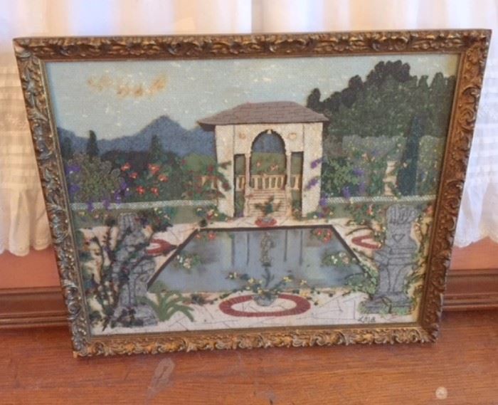 Framed embroidery of European garden with reflecting pool.