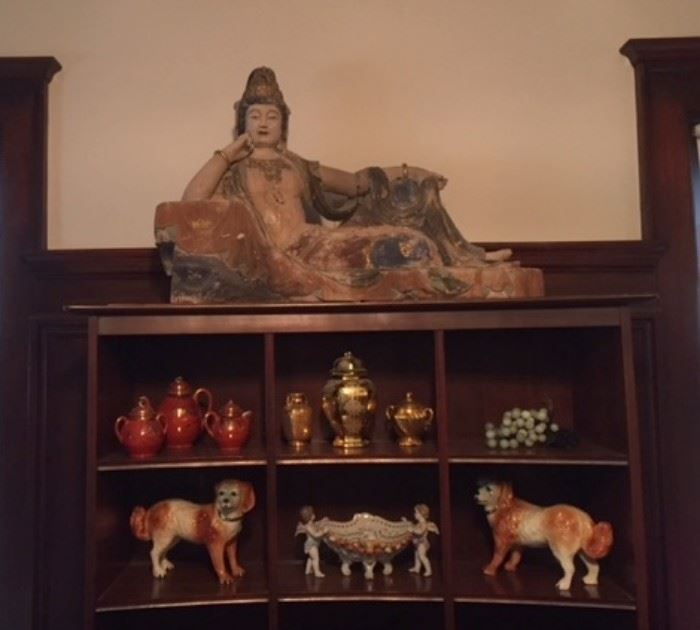 Polychrome Chinese  wood statue of a reclining lady in the dining room, atop a Willet Trans-Asia breakfront.
