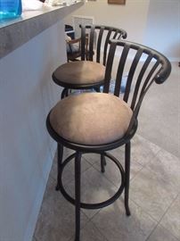 Two matching metal swivel bar stools with suede seats.