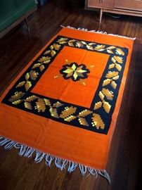 Throw rug in warm orange and blue design