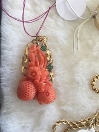 Finely carved coral, gold and emerald pendant