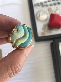 Enormous opal stone offset by a diamond in a heavy gold setting