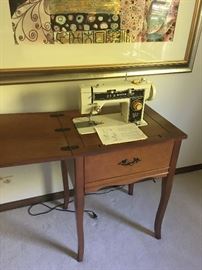 Vintage sewing machine in cabinet.