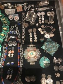 A collection of antique and vintange  silver jewelry including Tibetan gau boxes and Native American inlaid shell pendant. 