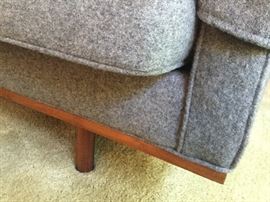 Corner of sofa showing wood bottom trim and leg