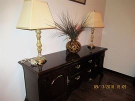 thomasville chest with a pair of stenciled green antique lamps