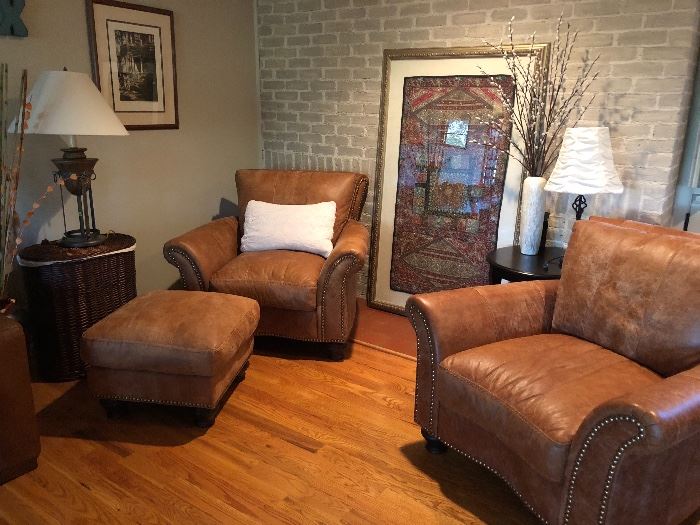 Matching stylish leather chairs and ottoman as well as large framed textiles