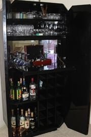 Drop down shelf inside bar. Bottle and stemware storage.