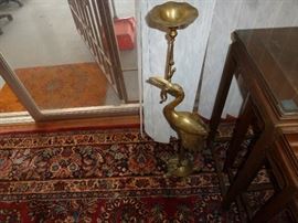 Brass stork with fish in mouth standing on the back of a tortise