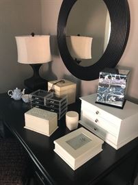 jewelry boxes, storage chests on top of "wenge" colored desk, table lamp and round mirror
