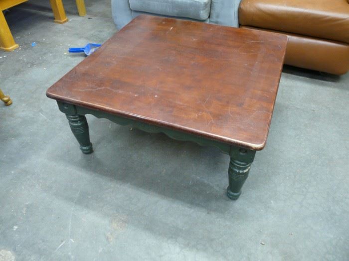This is a big square dark wood and green painted coffee table.