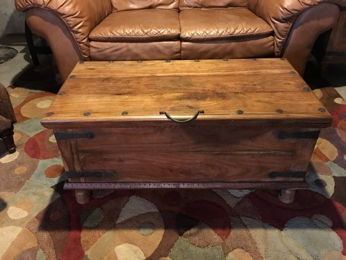 Rustic wooden trunk/coffee table with storage and wrought iron hardware.
