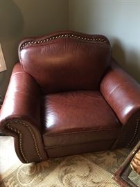 Pleather oversized club chair and ottoman with nail head trim.