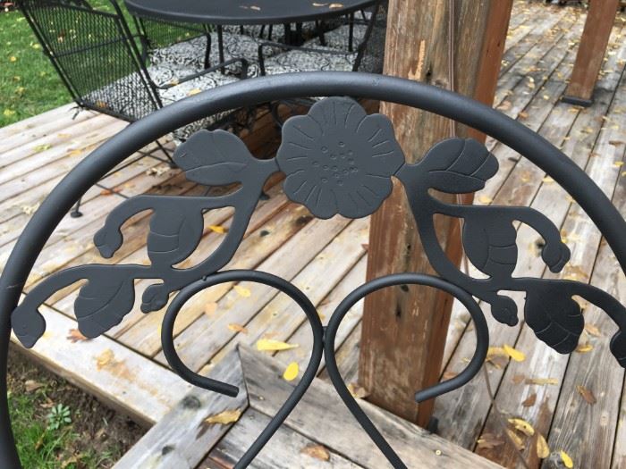 Adorable bistro wrought iron table with glass top and two chairs.