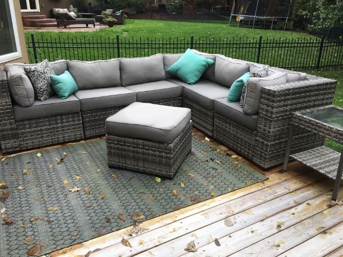 Grey, outdoor wicker L-shaped sofa and ottoman in beautiful condition! Covers (tarps) included.