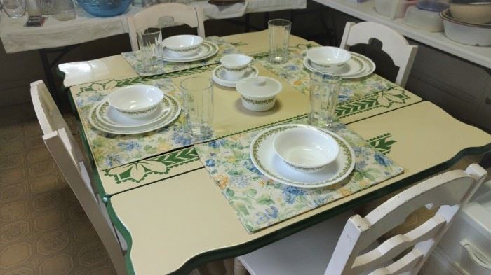 Enamel table with green trim and four white wood chairs 