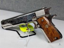 Colt M1911 A1 / Commemorative model 1911. Polished nickel finish. Engraved. WWII European Theatre, custom engraved, display case. Gun is in excellent condition. Does not appear to have been fired. Solid wood case in good condition, felt lining torn. 5152ETO .45 cal, FFL #272
