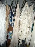 Selection of nice linens including crocheted pieces and quilt tops.