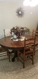 This pretty table has 4 ladder back chairs and  two leaves