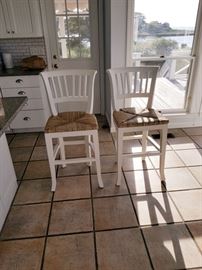2 highbacked distressed white wood counter stools with rush seats. $600