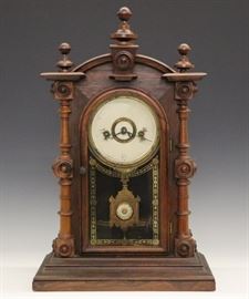 Welch "Patti VP" Shelf Clock - A late 19th century Welch "Patti VP" shelf clock. 8-day time and strike movement. Rosewood case with turned columns and finials on a molded base. Old finish with minor wear, dial very worn. Running when cataloged. 19" high.