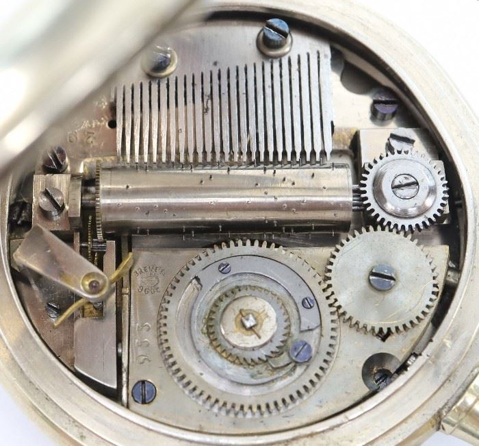 A Swiss pocket watch with incorporated on demand cylinder music box. SW, PS, 65 mm "Silver" OF, Engraved "Silver" dial with visible balance wheel and applied numerals. Serial #955. Some case wear. Winds, and sets roughly but runs and plays correctly when cataloged.