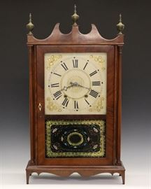 Eli Terry Pillar & Scroll Clock - A 19th century Eli Terry Jr, Terrysville Conn., Pillar & Scroll shelf clock. 30 hour time and strike wooden works with painted wooden dial. Mahogany case with scrolled top, cast Brass finials above a single door with lower eglomise panel flanked by turned columns on a scrolled base. Older refinishing with slight wear, slight dial wear and minor flaking on panel. Running when cataloged. 31" high overall.
