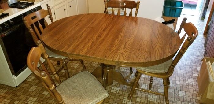 The large leaf comes out to make this into a round pedestal  kitchen table. Comes with 4 sturdy padded chairs.