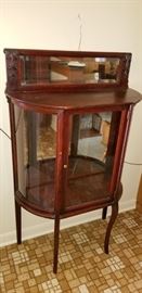 Antique curio cabinet with beveled mirror.