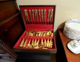 Gold electroplate set of silverware for sale which is siting on top of a wine cooler also for sale.