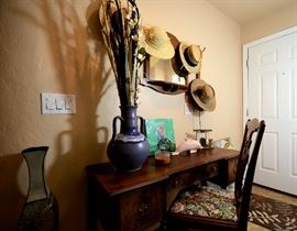Antique desk and tapestry and wood chair. Antique mirror with hooks to hang hats or other items.