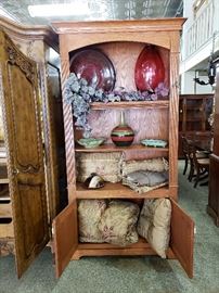 shelf with enclosed doors, linens, pottery