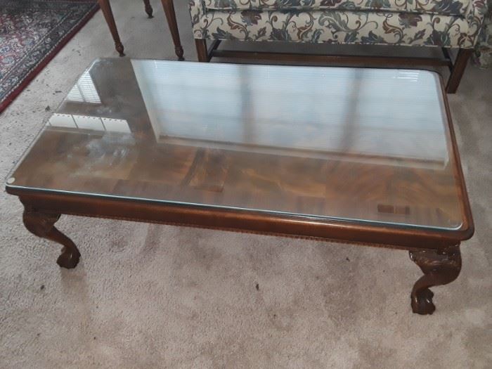 Glass topped coffee table with claw feet.