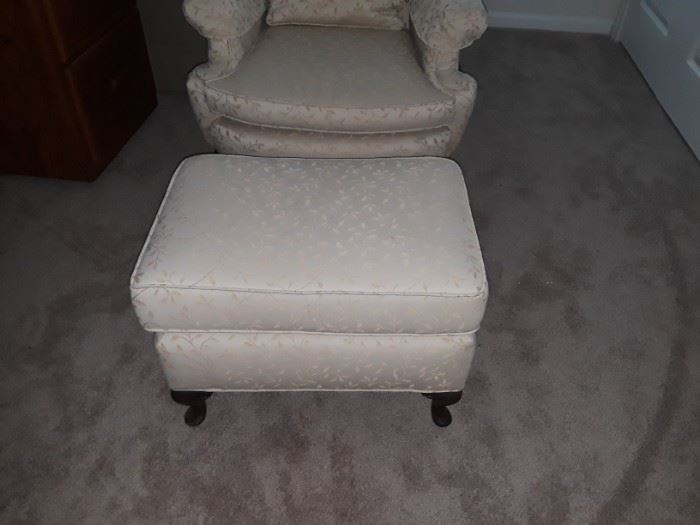 Cream wingback chair and footstool that has been professionally reupholstered.