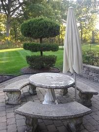 ANTIQUE STONE PATIO SET: TABLE: Diameter: 42”. Height: 28.5”. THREE BENCHES: Width: 50”. Height: 28.5”. Depth: 17”. 
