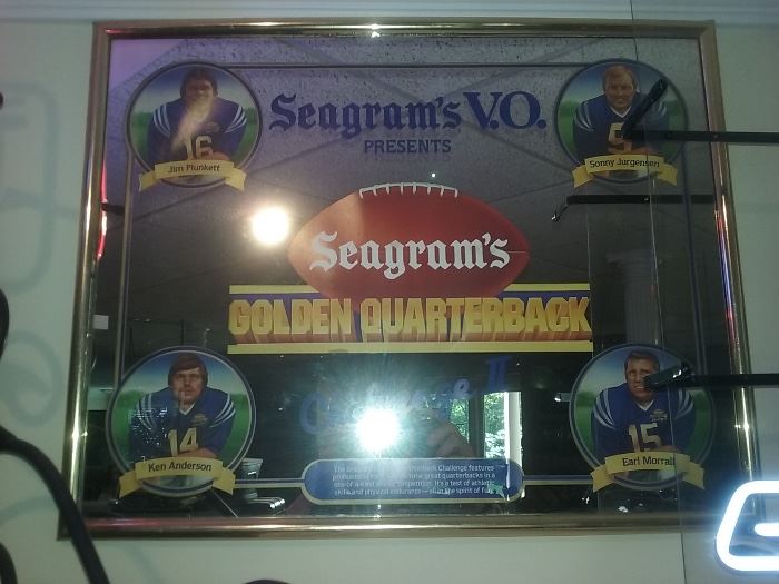 COLLECTIBLE SEAGRAM’S V.O. PRESENTS GOLDEN QUARTERBACK FRAMED PICTURE: Features: Jim Plunkett, Ken Anderson, Sonny Jurgensen, and Earl Morrall. Height: 20". Width: 24". 