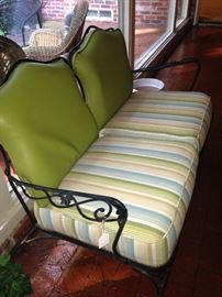 Wrought iron matching settee in lime, blue, and white