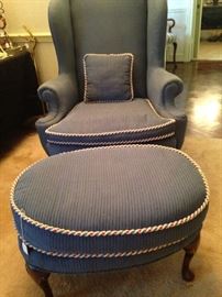 One of two blue wing back chairs; one matching ottoman