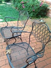 Two of four black patio chairs