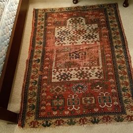 Oriental rug, worn and with a minor hole, 4’ x 3’