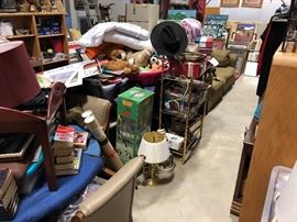 There is a golf caddy in here, small bakers rack of stuff, bunch of stuff animals in a kids pool, old quilts on each of the chairs.